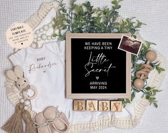 May include: A white babygrow with the text "Baby Richardson" in gold lettering, a black sign with the text "We have been keeping a tiny little secret arriving May 2024", and wooden blocks spelling out "BABY".