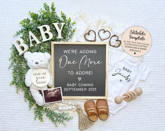 May include: A baby announcement featuring a chalkboard sign that reads "We're adding one more to adore! Baby coming September 2025". There is a white onesie with the name "Baby Jacobs" on it, a teddy bear holding a wooden circle that says "Here we grow again!" and a pair of brown baby shoes.