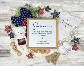 May include: A baby announcement featuring a white onesie with "Baby Richardson" printed on it, a framed sign with text, a teddy bear, and decorative stars. The sign reads "Summer is in the air and we have exciting news to share! Arriving January 2025."