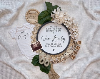 Peut inclure: Une grenouillère blanche pour bébé avec le texte "BABY Richardson" et un cœur. Une pancarte en bois avec le texte "WE ARE OVER THE MOON EXCITED TO SAY A New Baby WILL BE JOINING OUR FAMILY SOON!"  Une pancarte en bois avec le texte "ARRIVING November 2024".