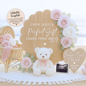 May include: A wooden sign with the text "Every Good & Perfect Gift Comes From Above" is decorated with roses and a teddy bear. A heart-shaped sign says "Baby Girl Parish January 2026". A wicker bassinet and two pink hearts are also present.