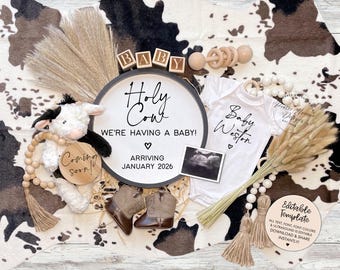 May include: A baby announcement featuring a plush cow, wooden blocks spelling "BABY", and a sign that reads "Holy Cow, We're Having a Baby!" with an expected arrival of January 2026. Includes a onesie, baby boots, and a sonogram.