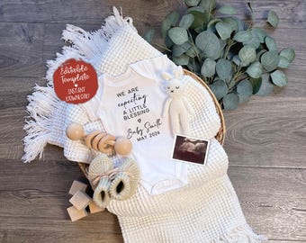 May include: A white onesie with the text "We are expecting a little blessing" and "Baby Smith May 2024". The onesie is lying on a white blanket with a wooden rattle, a small stuffed animal, and a sonogram photo.