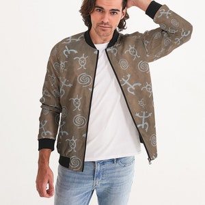 May include: A brown bomber jacket with a blue and white pattern of stylized symbols. The jacket has a zipper closure and a ribbed collar, cuffs, and waistband.