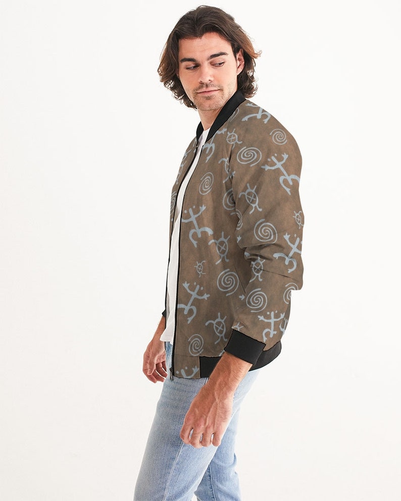 May include: A brown bomber jacket with a blue and brown pattern of stylized animal and spiral designs. The jacket has a black zipper and black ribbed cuffs and waistband.