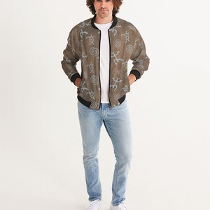 May include: A brown bomber jacket with a blue and white pattern of abstract symbols. The jacket has a zipper closure and a ribbed collar, cuffs, and waistband.