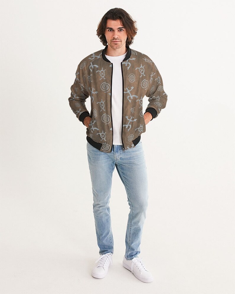 May include: A brown bomber jacket with a blue and white pattern of abstract symbols. The jacket has a zipper closure and a ribbed collar, cuffs, and waistband.