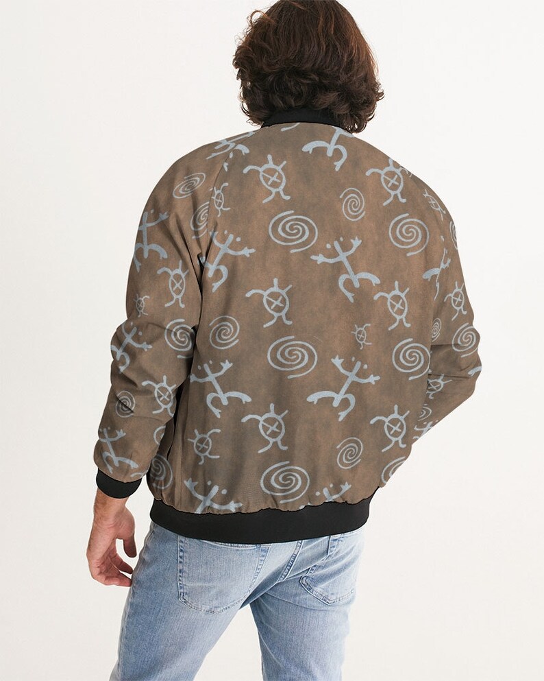 May include: A brown bomber jacket with a blue and white pattern of stylized turtles and spirals. The jacket has a black ribbed collar, cuffs, and waistband.
