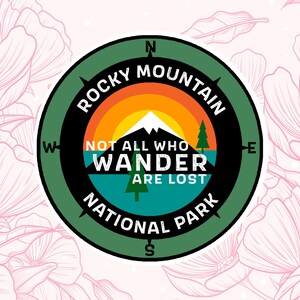 May include: A green and black compass-style sticker with the text "Rocky Mountain National Park" and the quote "Not all who wander are lost".