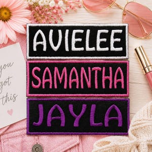 May include: Three rectangular black embroidered patches featuring personalized names in different thread colors. The top patch displays the name AVIELEE in white, the middle patch shows SAMANTHA in pink, and the bottom patch features JAYLA in purple.