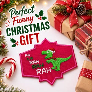 Puede incluir: Imagen navideña con un parche rosa y rojo con un dinosaurio verde con gorro y bufanda de Papá Noel. El parche dice "Fa La Rah Rah Rah". La imagen también incluye regalos envueltos, un bastón de caramelo y el texto "Perfect Funny Christmas Gift."