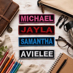 May include: Four rectangular black fabric patches with embroidered names. The top patch has pink text reading MICHAEL, the second has red text reading JAYLA, the third has blue text reading SAMANTHA, and the bottom has white text reading AVIELEE.