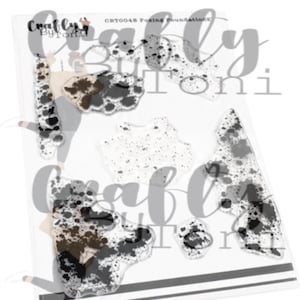 May include: A clear photopolymer stamp set labeled CBT0048 Foxing Foundations by Craftly By Toni. The set includes various irregular shapes featuring black and brown speckled, mottled, and cow-print patterns on a transparent backing sheet.
