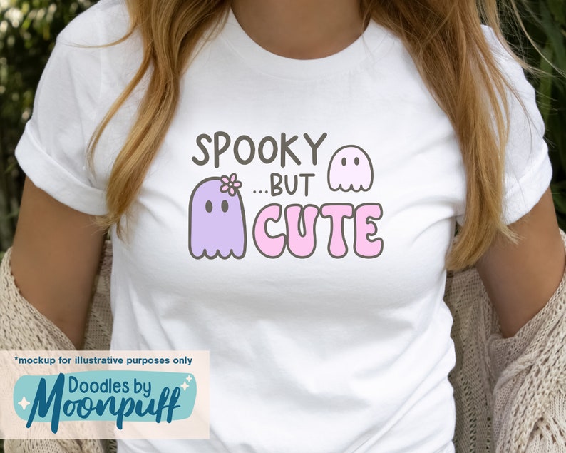 May include: White t-shirt with a purple ghost with a flower on its head and the text "Spooky...But Cute" in pink letters.