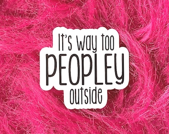 Op de afbeelding: Een witte sticker met de tekst "It's way too PEOPLEY outside" in een zwarte, vette letter. De sticker is geplaatst tegen een levendige, felroze, fuzzy achtergrond.
