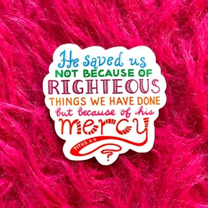 May include: A colorful sticker with the text "He saved us not because of righteous things we have done but because of his mercy" and the scripture reference "Titus 3:5".