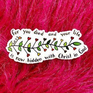 May include: White sticker with a black vine design with red hearts and green leaves. The sticker has the text "for you died and your life is now hidden with Christ in God" and the reference "Col 3:3".