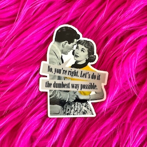 May include: A die-cut sticker featuring a black and white illustration of a couple in mid-century attire. The person on the left wears a suit, and the person on the right wears a yellow top. Text reads: No, you're right. Let's do it the dumbest way possible.