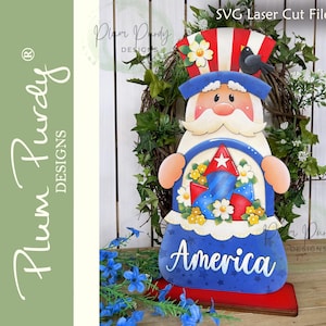 May include: A wooden Uncle Sam figure with a red, white, and blue color scheme. The figure has a hat with red and white stripes, a blue coat, and holds a basket with fireworks and the word "America".