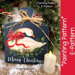May include: A painted wooden cutting board with a white goose, red bow, and holly leaves. The board has the text "Merry Christmas" and "Renee Mullins 2021".