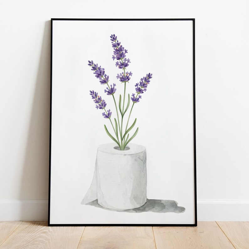 May include: A framed watercolor print featuring a roll of white toilet paper with lavender sprigs emerging from the center. The lavender has purple flowers and green stems and leaves. The print is set against a white background.