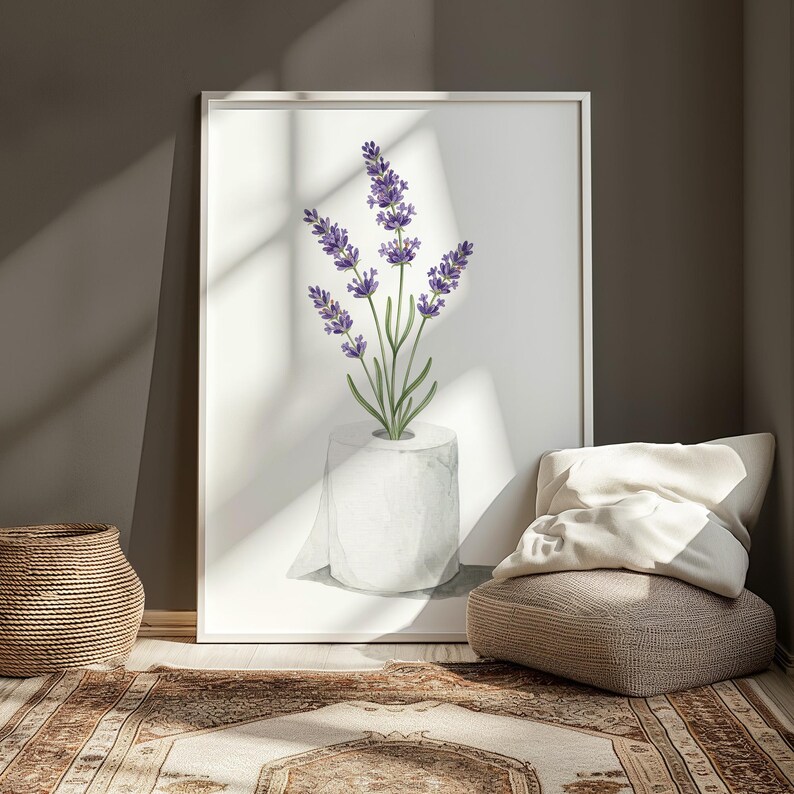 May include: A framed art print featuring a watercolor illustration of lavender sprigs emerging from a roll of toilet paper. The lavender has purple flowers and green stems. The print is displayed in a room with a woven basket and a patterned rug.