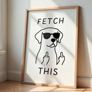 Könnte beinhalten: Ein gerahmter Kunstdruck mit einer Schwarz-Weiß-Illustration eines Hundes mit Sonnenbrille, der den Mittelfinger zeigt. Die Worte "FETCH THIS" sind über und unter dem Hund gedruckt.