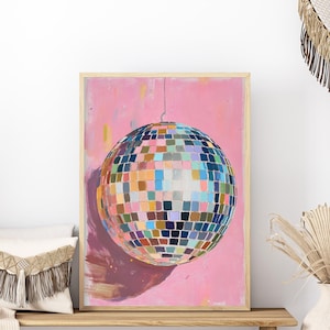 a vibrant, colorful disco ball with a pink background, hanging from the center of the frame.