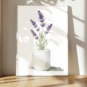 May include: Watercolor art print featuring lavender sprigs in a roll of white toilet paper. The lavender has purple flowers and green stems. The artwork is displayed on a white background, with shadows from sunlight.