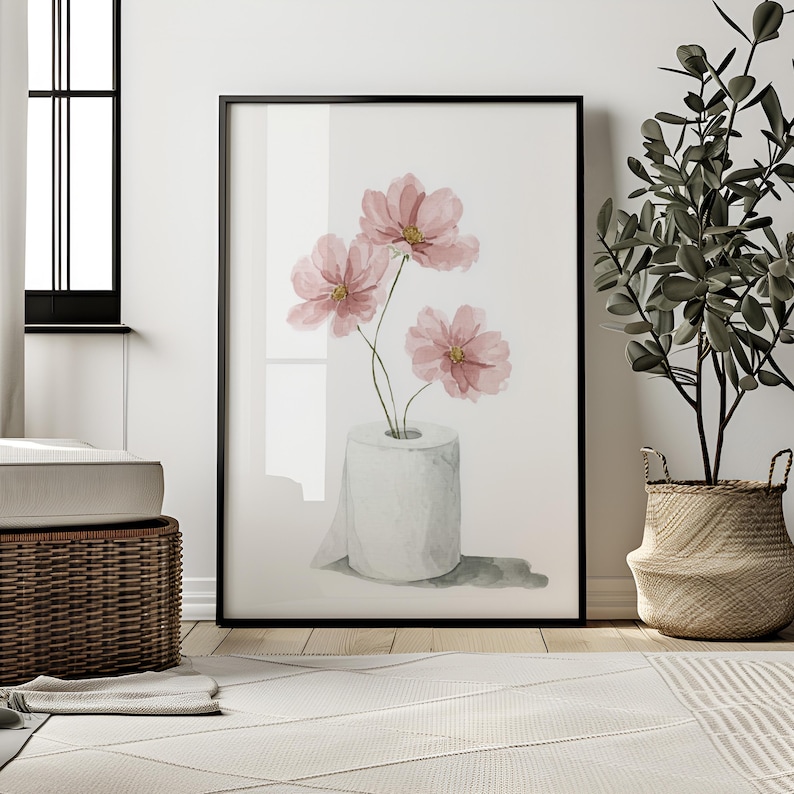 Puede incluir: Impresi&oacute;n art&iacute;stica enmarcada con una ilustraci&oacute;n en acuarela de flores de cosmos rosas en un rollo de papel higi&eacute;nico. La obra de arte tiene un fondo blanco y est&aacute; enmarcada en negro. Una versi&oacute;n humor&iacute;stica del arte floral.