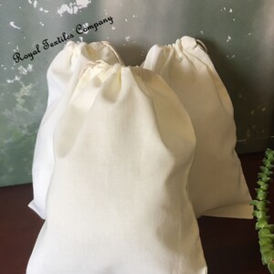 May include: Three off-white cotton drawstring bags, made by Royal Textiles Company.