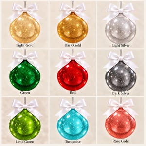 May include: A grid of nine round, glittery Christmas ornaments, each topped with a white satin bow. The colors include light gold, dark gold, light silver, green, red, dark silver, lime green, turquoise, and rose gold, with labels below each.