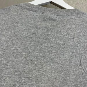 Puede incluir: Una camiseta gris jaspeada con cuello redondo.
