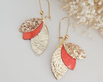 May include: Gold and coral leaf-shaped dangle earrings. The earrings are made of leather and have a glitter finish.
