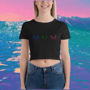 May include: A black cropped t-shirt with three colorful butterfly designs. The butterflies are in shades of blue, green, and pink.