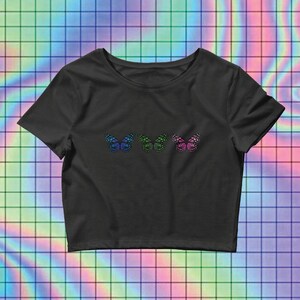 May include: Black cropped t-shirt with three colorful butterfly designs on the front.