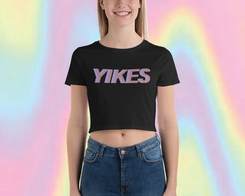 May include: A black cropped t-shirt with the word "YIKES" printed in pink and blue letters.