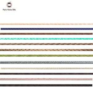 May include: A range of colourful cords and ropes in shades like beige, navy blue, brown, teal, and green. The image features the text "Paris Vente Stifa" and a spool icon. These cords are suitable for crafts and jewellery making, offering a variety of options for creative projects.