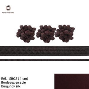 Puede incluir: Tres borlas de seda marr&oacute;n con un ribete trenzado. Las borlas tienen un di&aacute;metro de 1 cm. El ribete tiene 1 cm de ancho. El ribete es negro. Las borlas son de seda burdeos. Ref: SBO2 (1 cm).