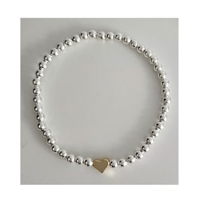 May include: A silver beaded bracelet with a gold heart charm.