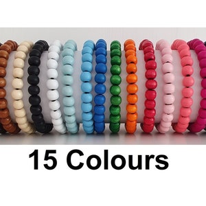May include: Fifteen wooden bracelets in a variety of colours, including brown, beige, black, white, light blue, blue, green, orange, red, pink, coral, magenta, purple, and dark purple. 15 Colours.