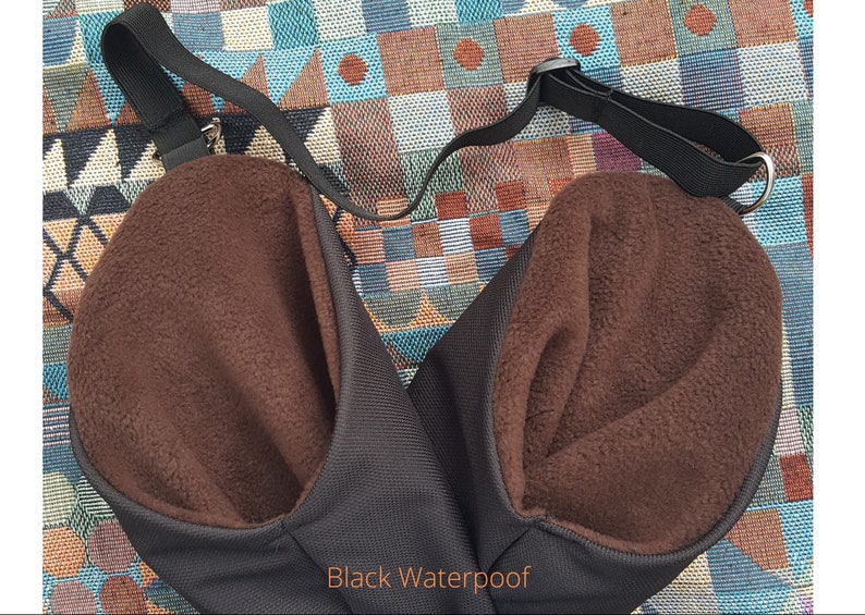 May include: A black waterproof bag with a brown fleece lining. The bag has a single adjustable strap and a metal ring.