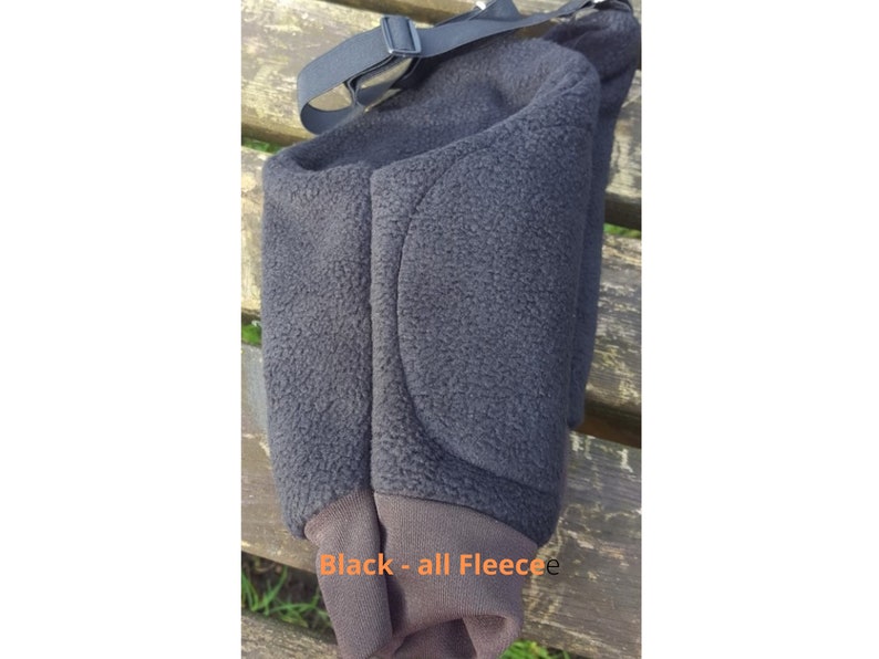 May include: Black fleece knee pad with a strap. The knee pad has a padded area on the back.