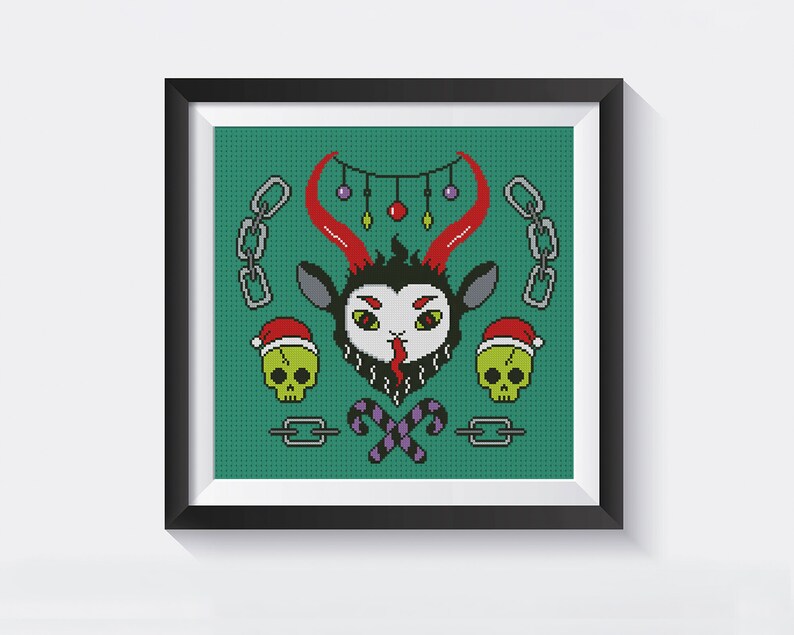 May include: A framed cross-stitch design featuring a green background with a black and red goat head with horns, two green skulls with red Santa hats, candy canes, and chains. The design has a festive, Christmas theme.