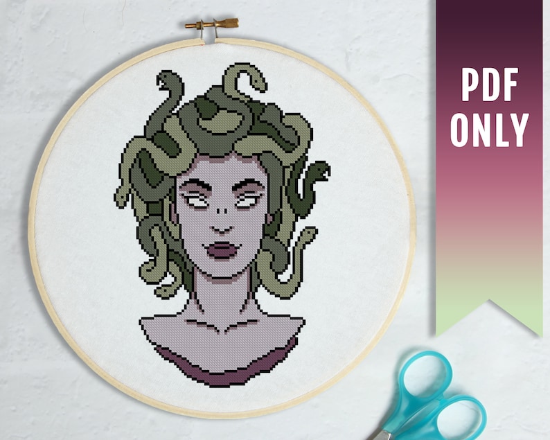 May include: Cross stitch pattern of Medusa, a Greek mythological figure with snakes for hair. The pattern is in a circular hoop and features a detailed design of Medusa's face and snakes.