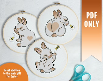 May include: Three embroidery patterns featuring cute bunnies with a heart on their chest and a bee. The patterns are on white backgrounds with a brown border.
