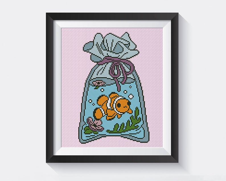May include: A cross-stitch pattern of a blue and white bag with a purple ribbon, containing a small orange and white fish with bubbles. The bag is on a pink background.