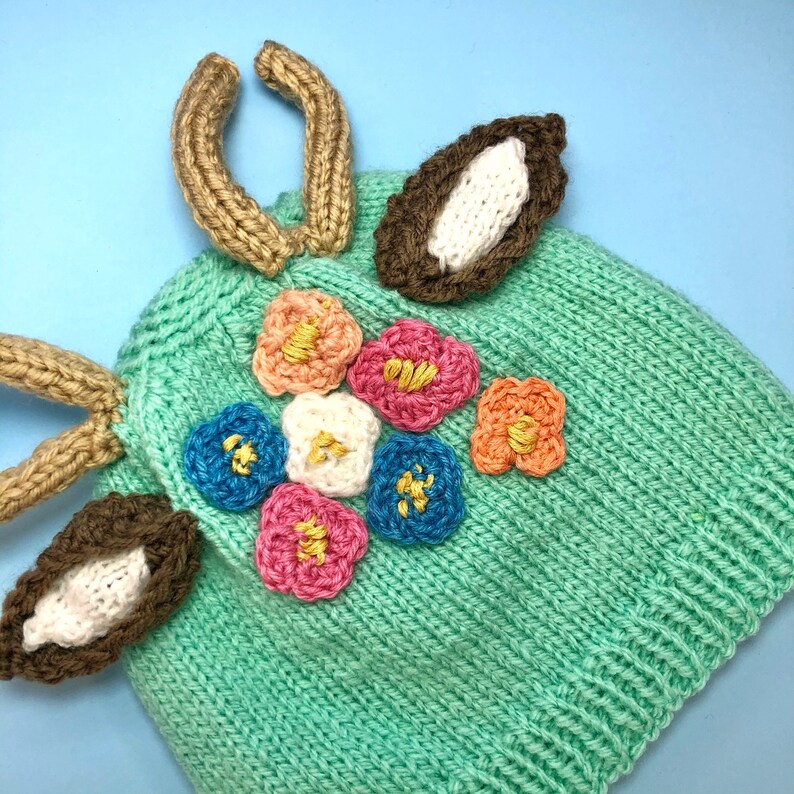 Together in wool cap and mittens baby reindeer and small dog carry by hand crochet