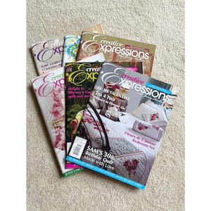 May include: A stack of eight Creative Expressions magazines featuring various quilting and embroidery projects. The covers feature colorful floral designs and text such as "Be My Valentine", "Sam's 30th Birthday Quilt", and "Fleurs de L'Amour Bedroom Set".