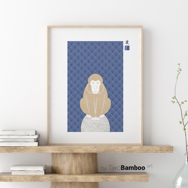 May include: A framed print of a brown monkey sitting on a rock, with a blue background featuring a white wave pattern. The Japanese character "女" is in the top right corner of the print. The print is titled "by TwoBamboo art".